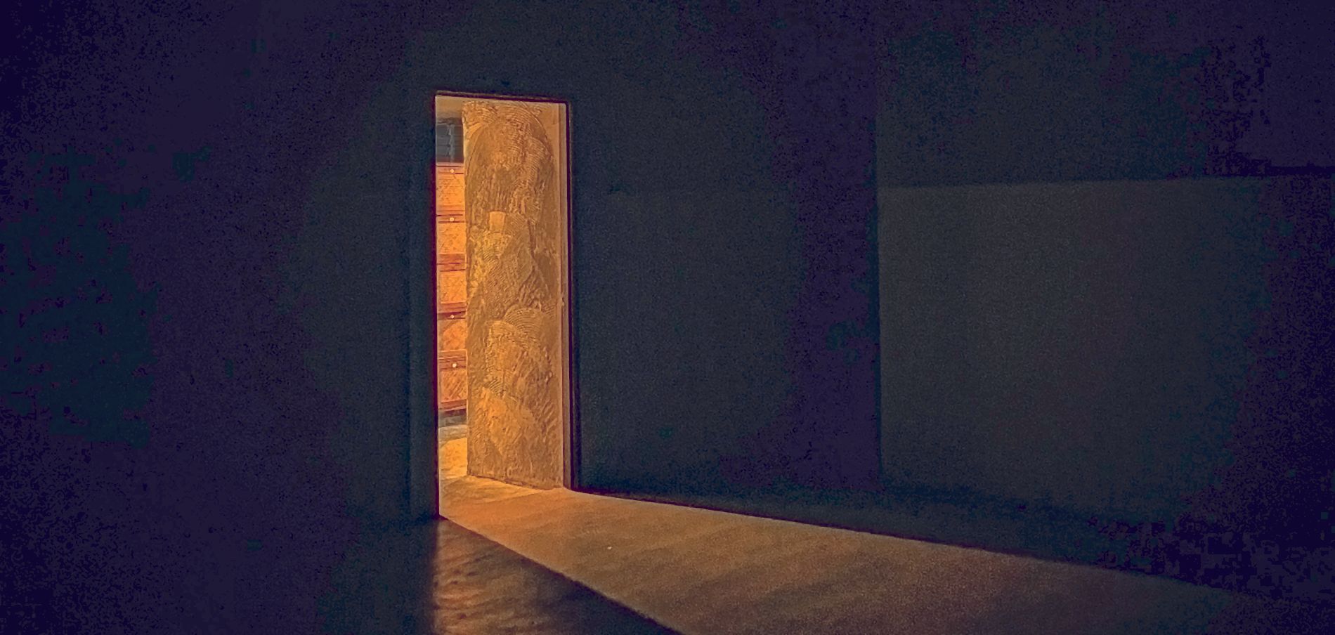 A door standing open, light falling across the floor beyond